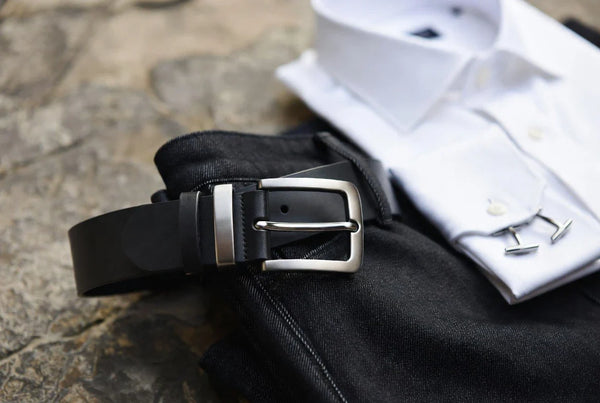 Silver-tone belt styled with tailored trousers and denim in a premium editorial flat lay