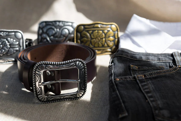 Western belt buckles styled with a leather belt and denim in a premium editorial setting