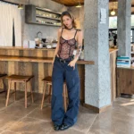 Black belt for women styled with low-rise navy trousers and a leopard-print top for a vintage-inspired Y2K look