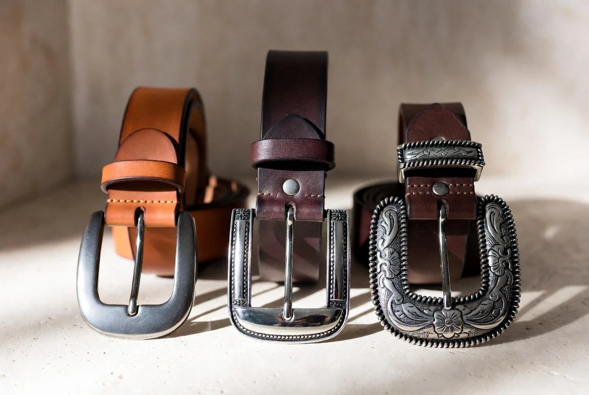Comparison of smaller and larger cowboy belt buckle styles on leather belts