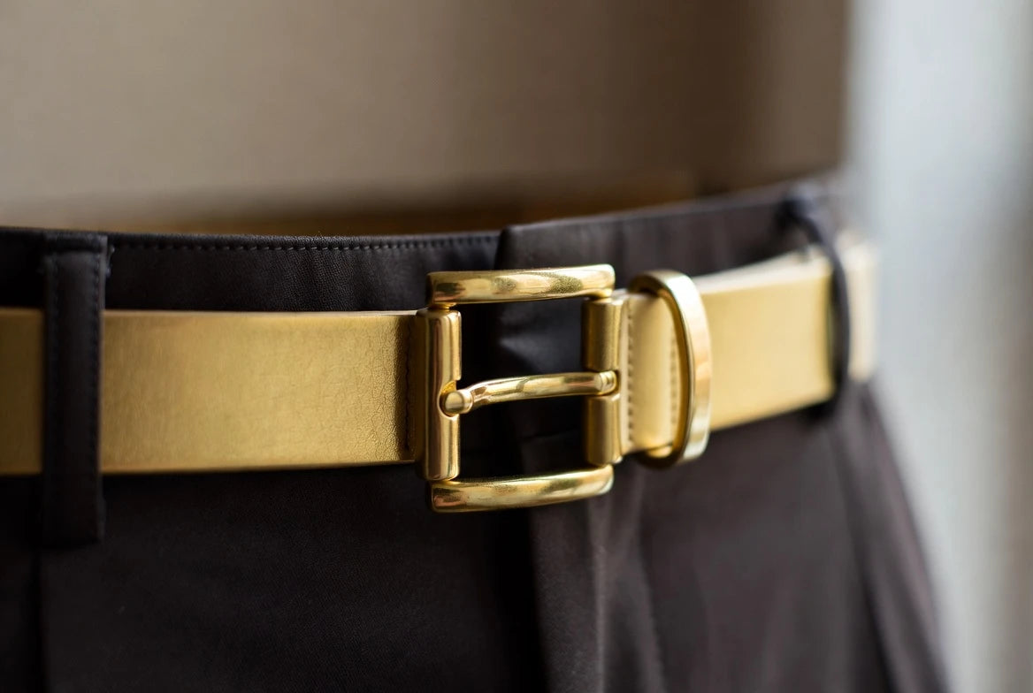 Gold belt fastened at the middle hole with a neat tail for balanced fit