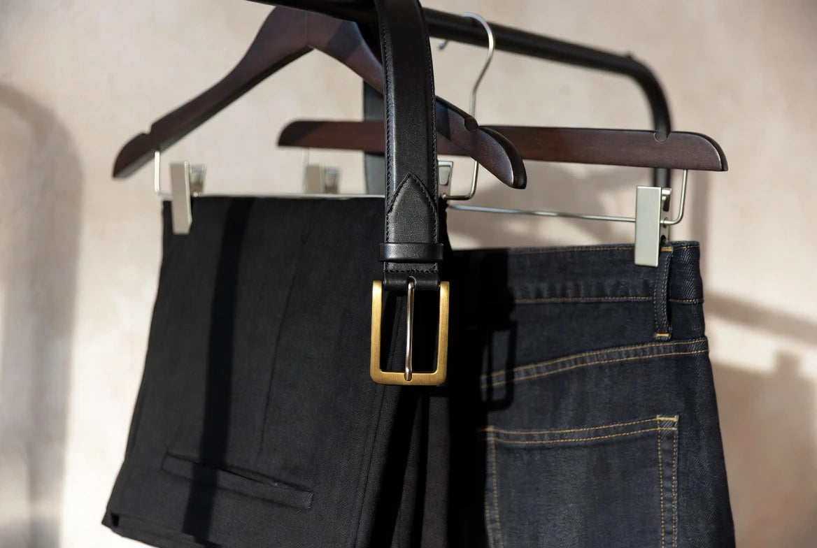 Gold-buckle belt compared with tailored trousers and dark denim to show outfit balance