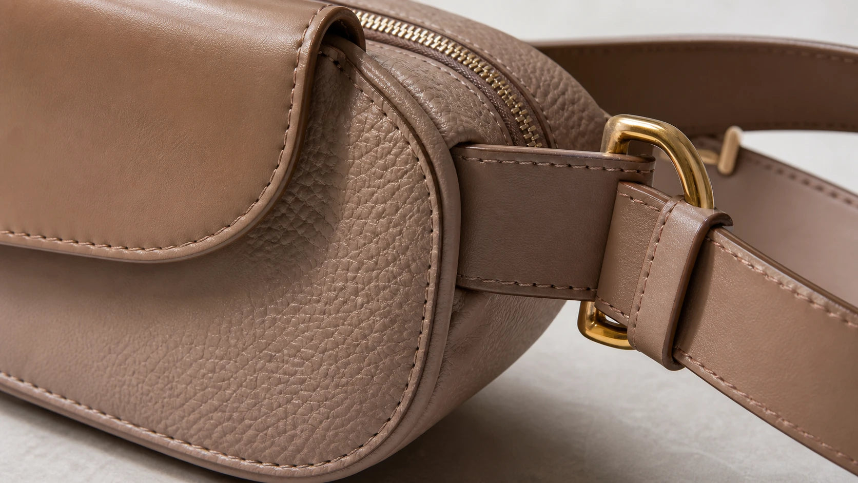 Close-up of leather belt bag materials showing surface finish, stitching, and hardware