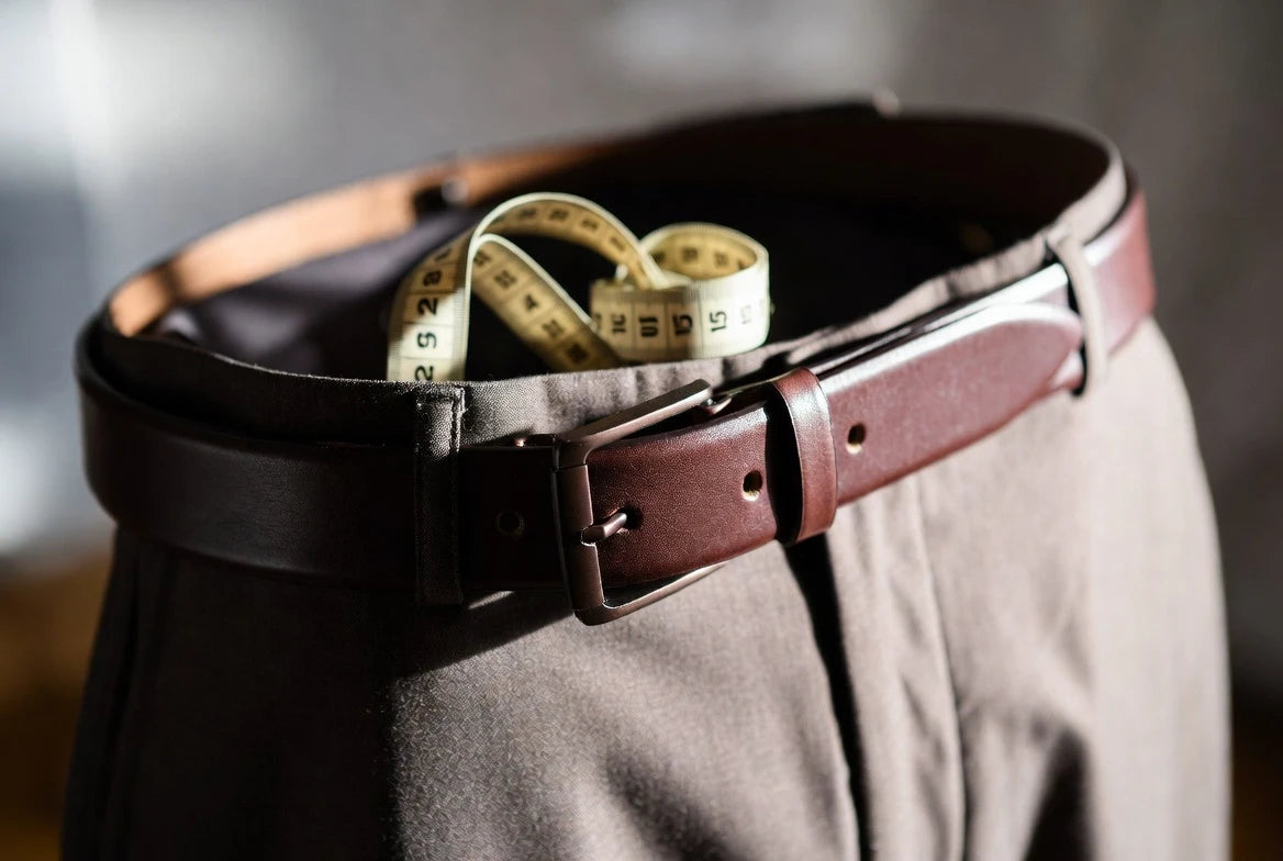 Men's leather belt fitted on the middle hole with tailored trousers