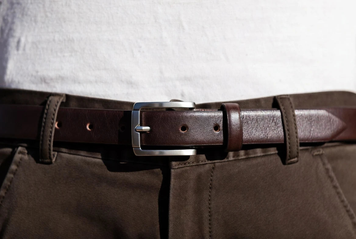 Silver-tone belt fitted on the middle hole with a neat tail on tailored trousers